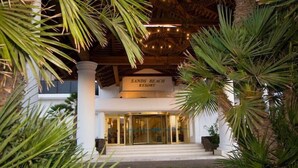 The entrance of Sands Beach Resort with a sign above the door, surrounded by palm trees. - Holiday Villa with shared pool in Costa Teguise, Las Cucharas (Costa Teguise)