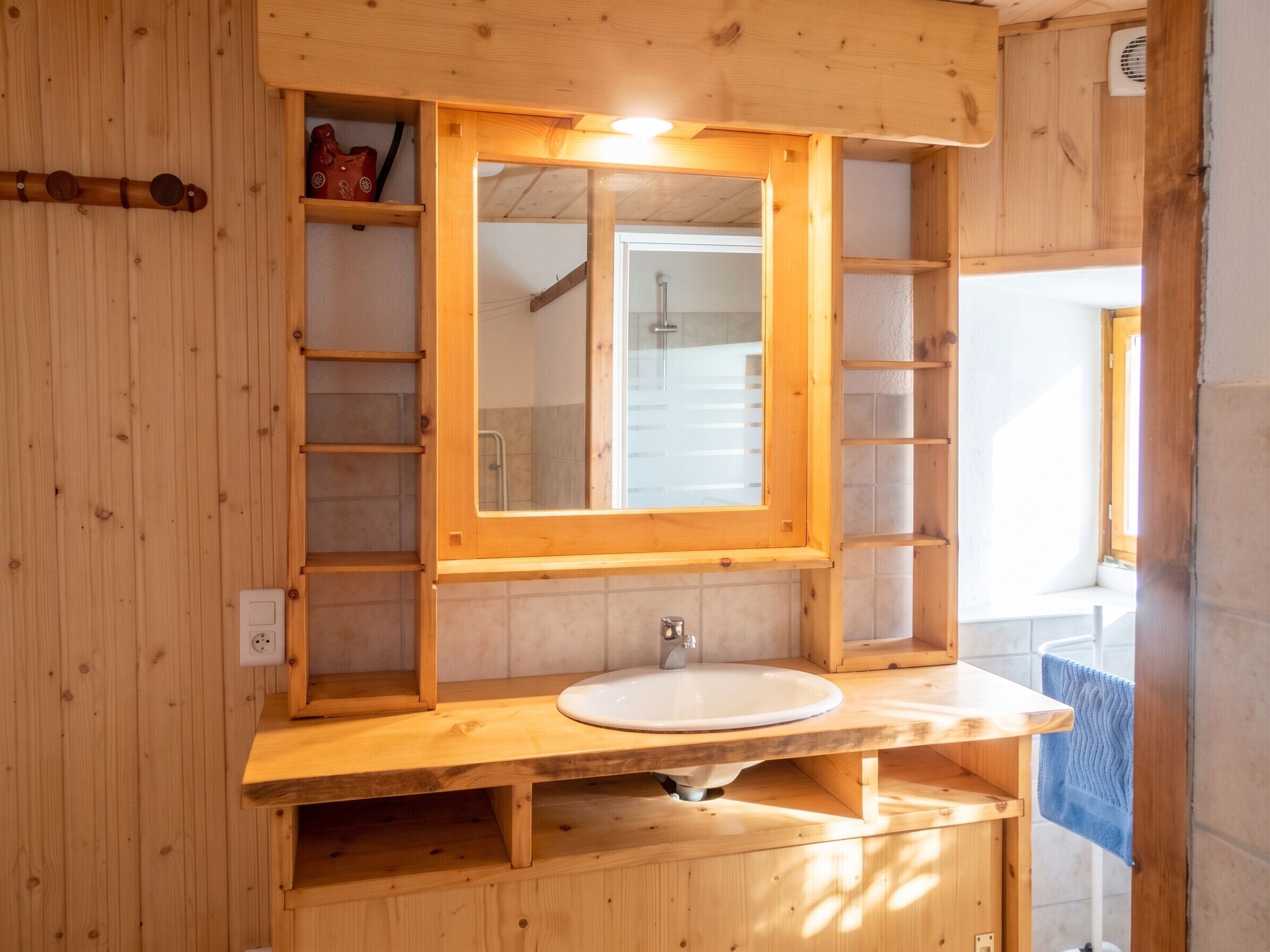 Ein Badezimmer aus Holz mit einem großen Spiegel, einem Waschbecken und einem Handtuchhalter.