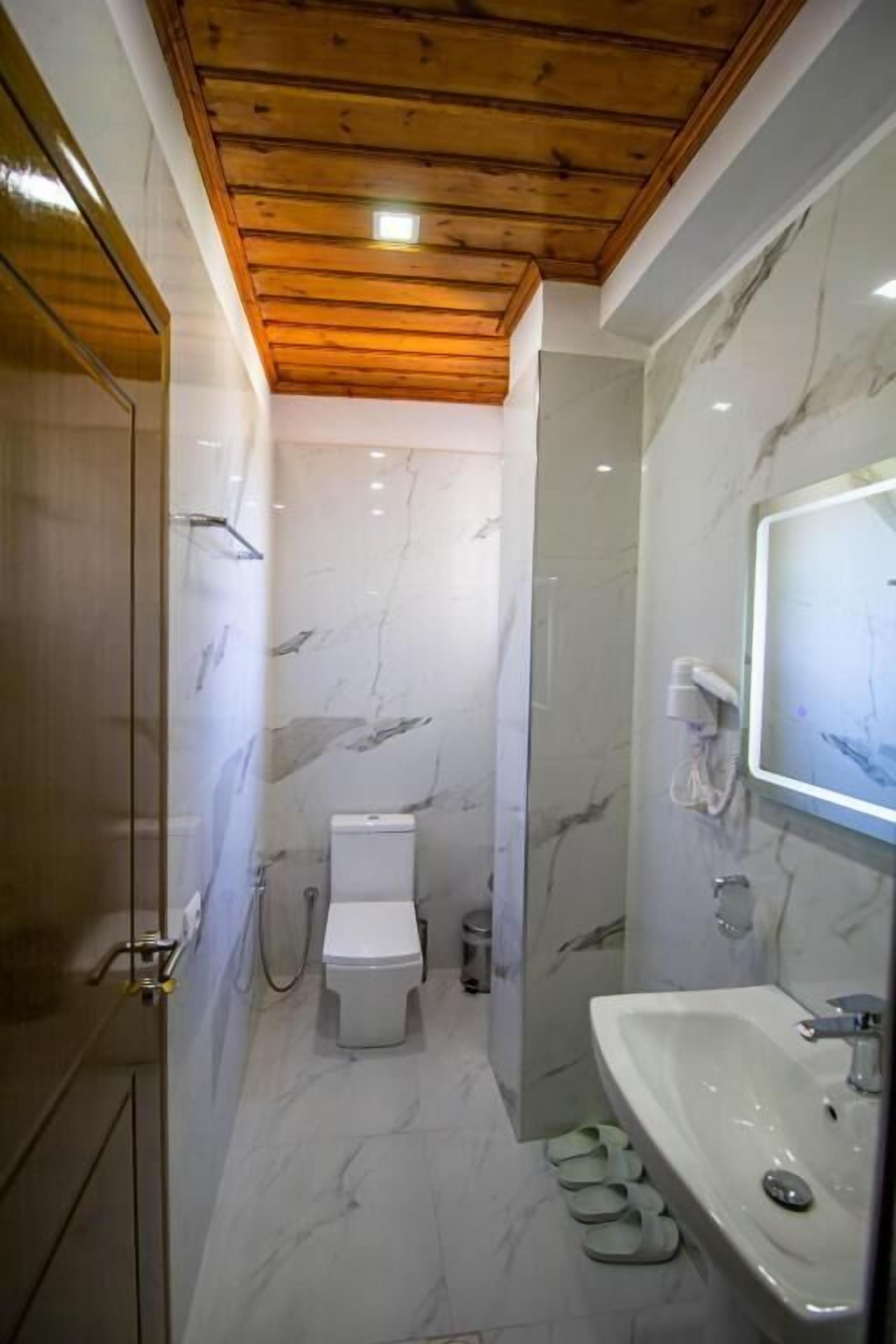 Un baño con inodoro, lavabo y zona de ducha.