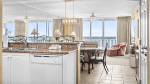 Eine moderne Küche mit einer Granit Arbeitsplatte, weißen Schränken und Blick aufs Meer.