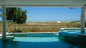 A swimming pool with a view of the beach and ocean.