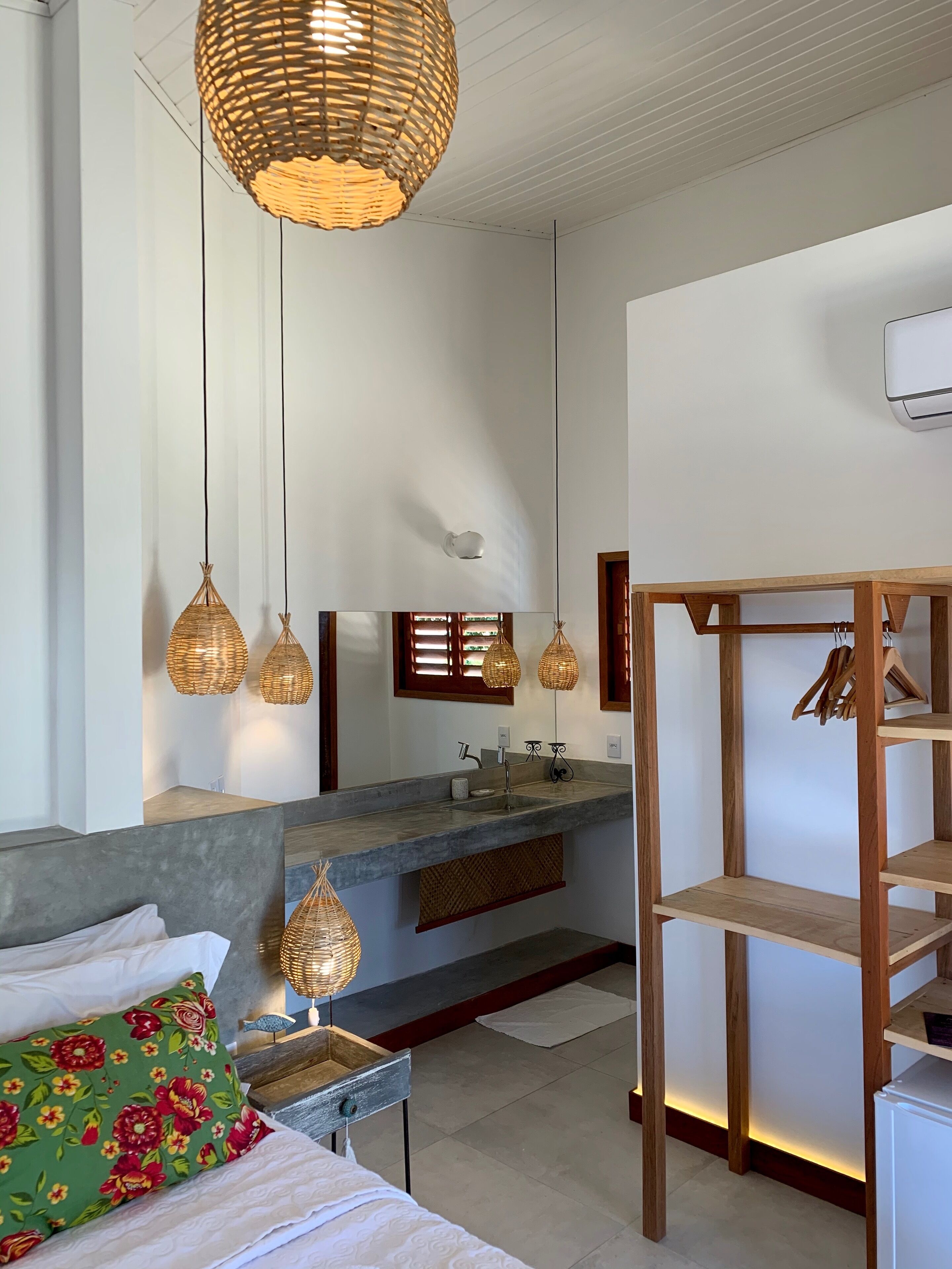 Un baño moderno con un espejo grande, un lavamanos y un estante de madera.