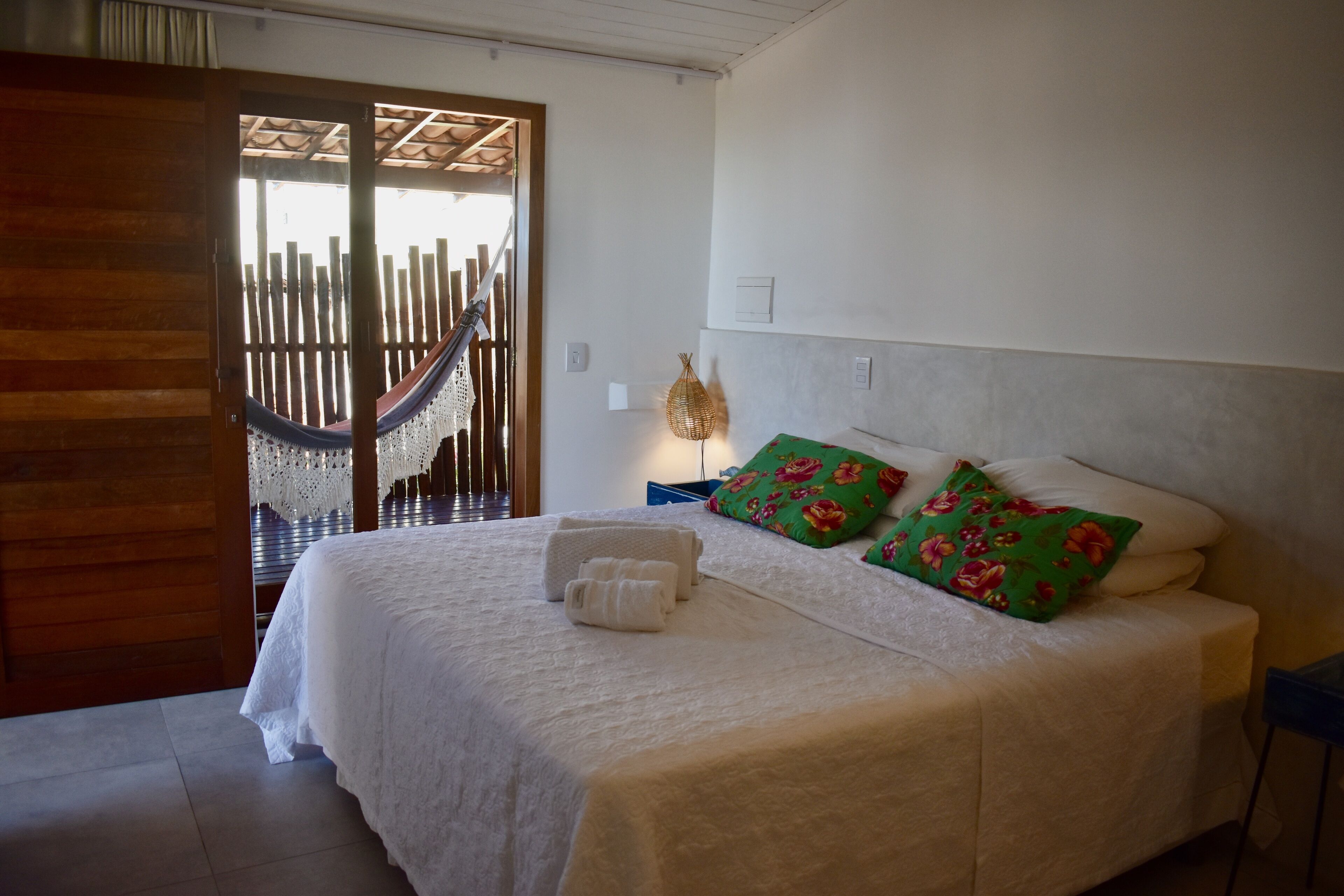 Une chambre à coucher avec un lit, des oreillers et un hamac.