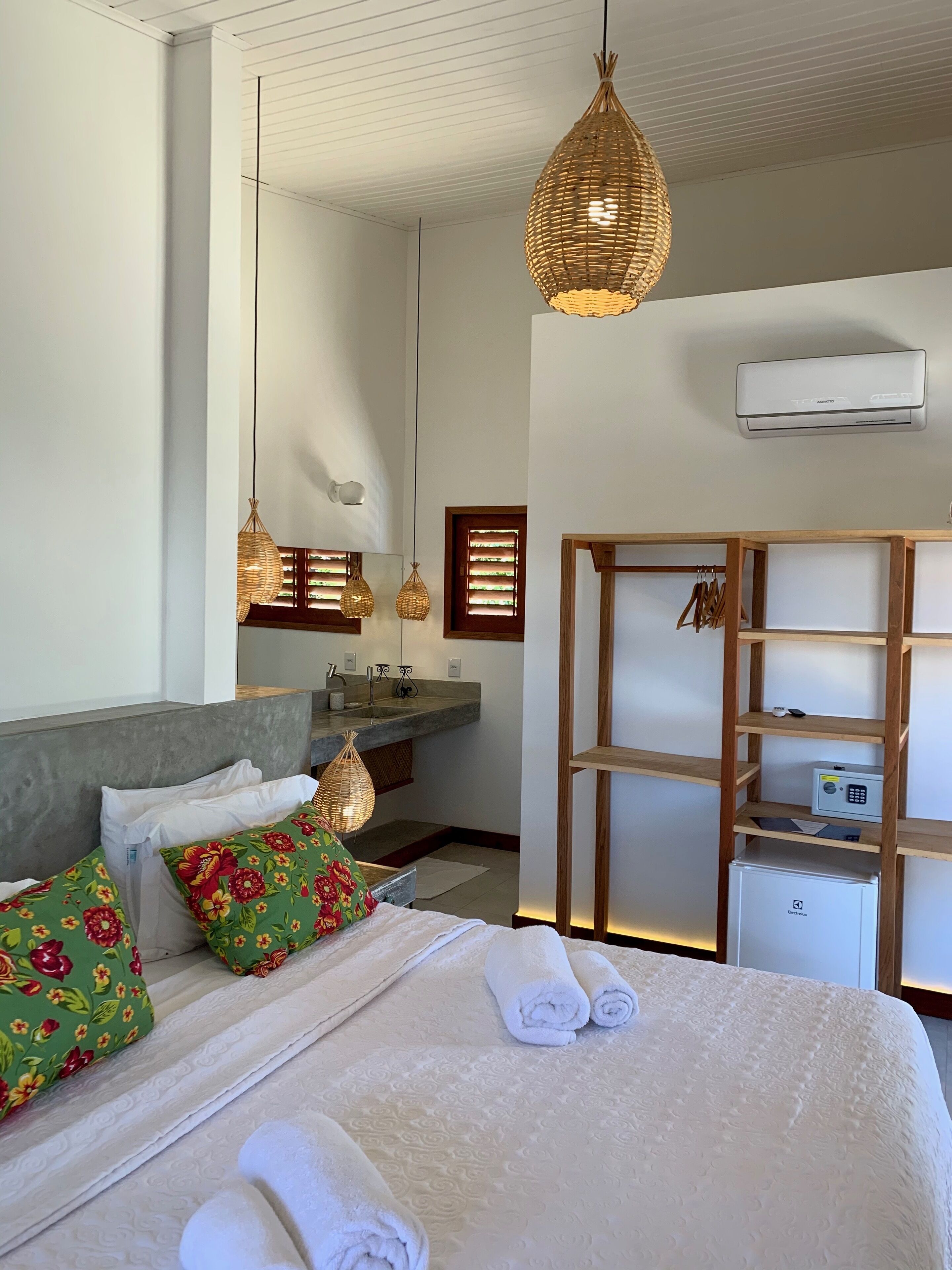 Un dormitorio moderno con una cama grande, un tocador con lavabo y un vestidor.