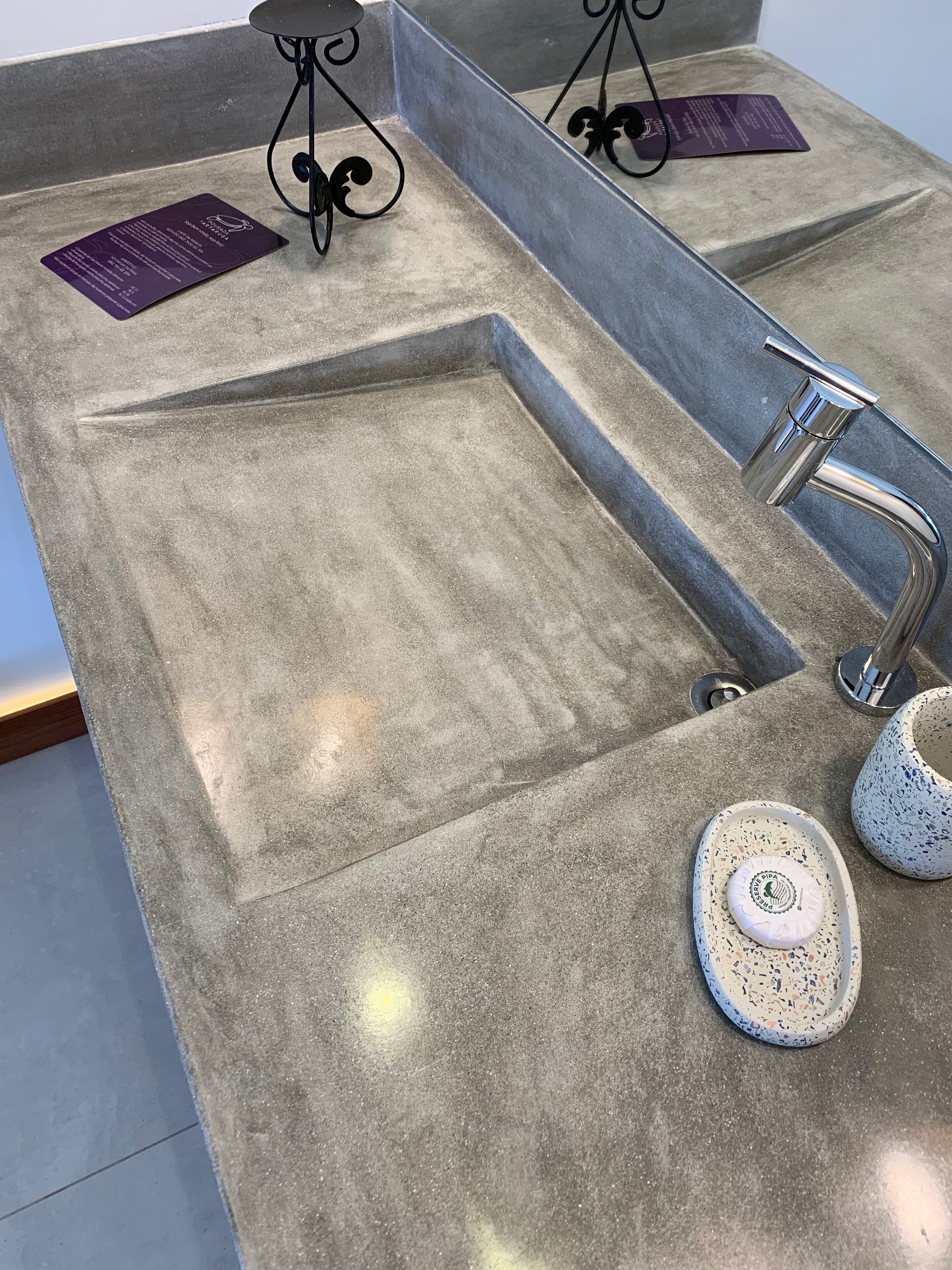 A granite countertop with a built-in sink, a stainless steel faucet, and two ceramic plates with a logo.
