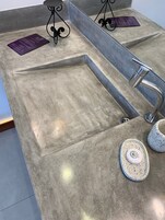 A granite countertop with a built-in sink, a stainless steel faucet, and two ceramic plates with a logo.