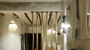 Une chambre à coucher comprenant un lit, des oreillers, une tête de lit, une lampe fixée au mur et un luminaire suspendu.