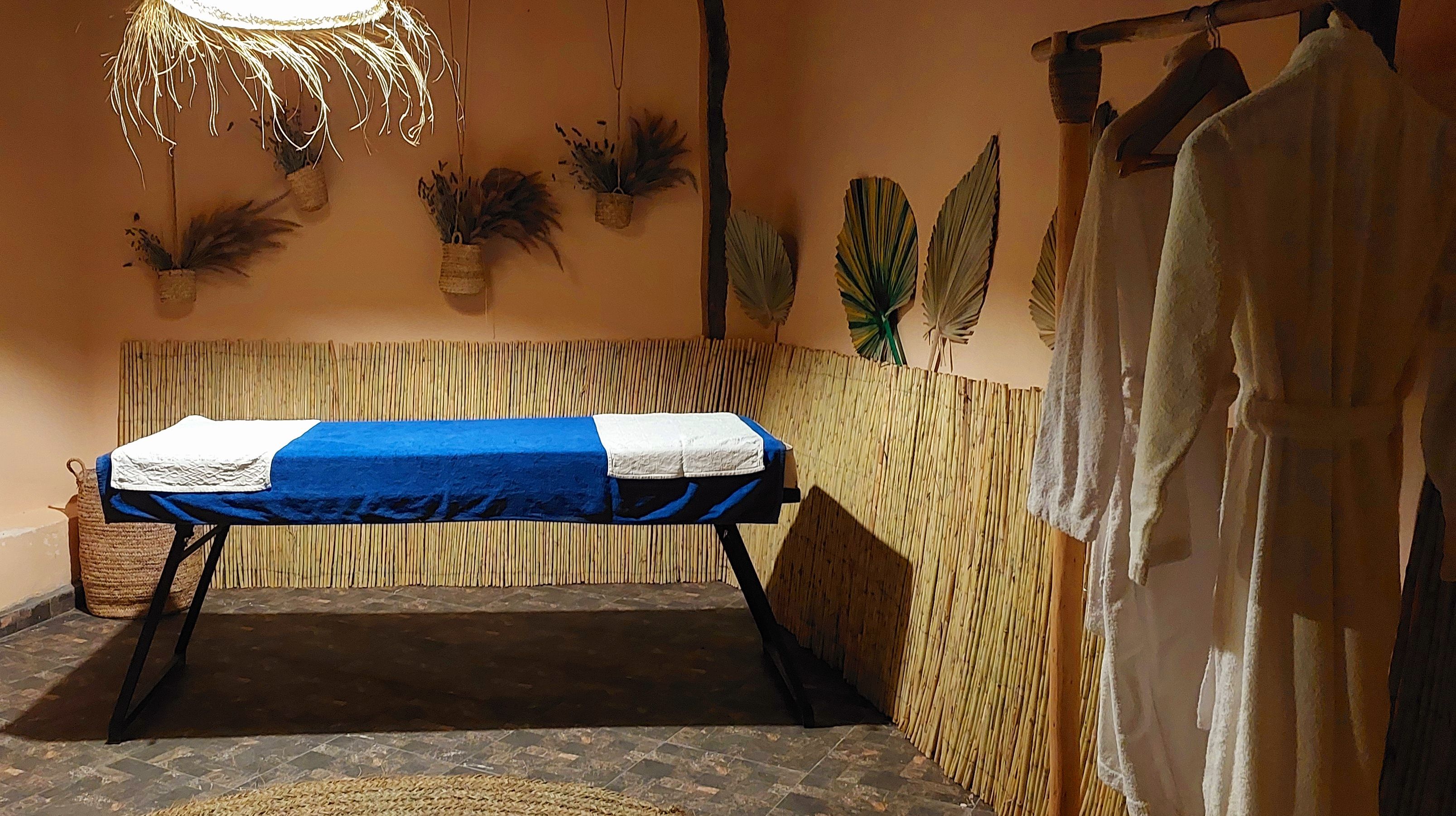 Una habitación con cama, pared de tejido y plantas colgantes.