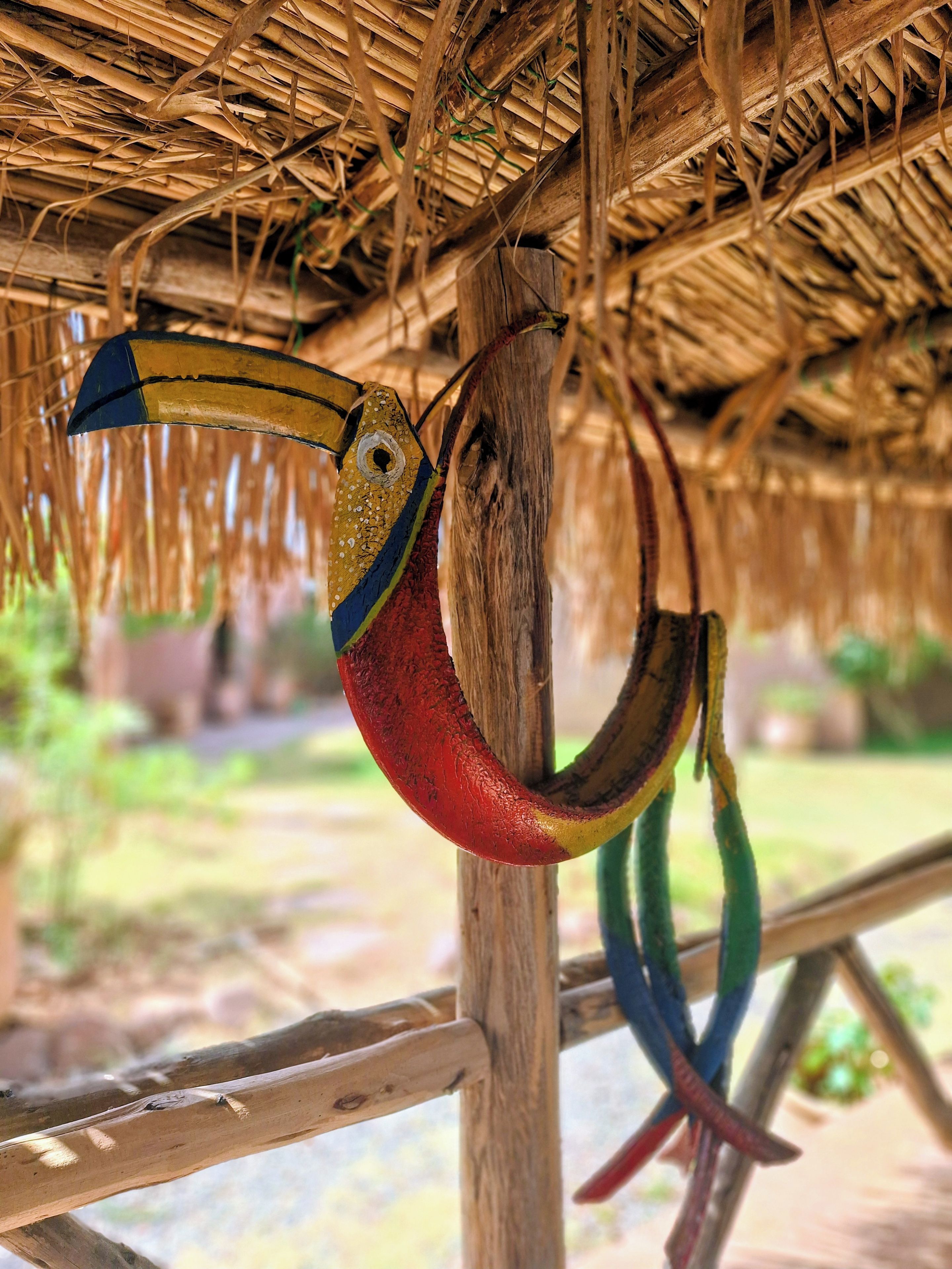 Une construction rustique en bois, dotée d’un toit de chaume et décorée de motifs colorés représentant des poissons.