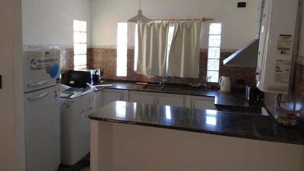 A kitchen with a refrigerator, microwave, and sink.