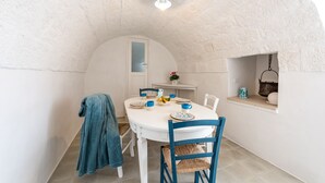 A dining area with a white table, blue chairs, and a white ceiling. - D'aprile Dimore (Polignano a Mare)