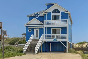 A two-story beach house with a balcony, a staircase, and a sign that reads "Sea View".