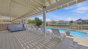 A covered deck with a pool, lounge chairs, and a sofa. - Sandpiper Crossing | 555 ft from the beach | Private Pool, Hot Tub (Virginia Beach)