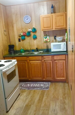 Kitchen features a central island with a sink, a stove, and a microwave.