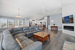 A spacious living room with a sectional sofa, a coffee table, and a fireplace.