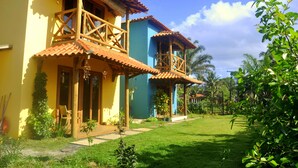 A two-story house with a balcony, a small porch, and a garden.