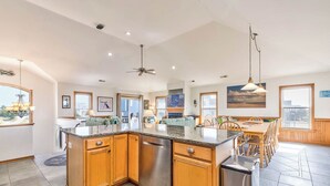 A spacious kitchen with wooden cabinets, a stainless steel dishwasher, and a granite countertop. - Sea Song II | 470 ft from the Beach | Private Pool, Hot Tub | Nags Head (Nags Head)