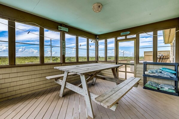Guests can enjoy a seating area with a table and benches, surrounded by large windows offering views of the surrounding landscape.