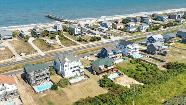 A coastal residential area with houses, a pier, and a beach. - Sea Song II | 470 ft from the Beach | Private Pool, Hot Tub | Nags Head (Nags Head)