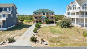 A two-story house with a front porch, a covered entryway, and a small front yard with landscaping. - Sea Song II | 470 ft from the Beach | Private Pool, Hot Tub | Nags Head (Nags Head)