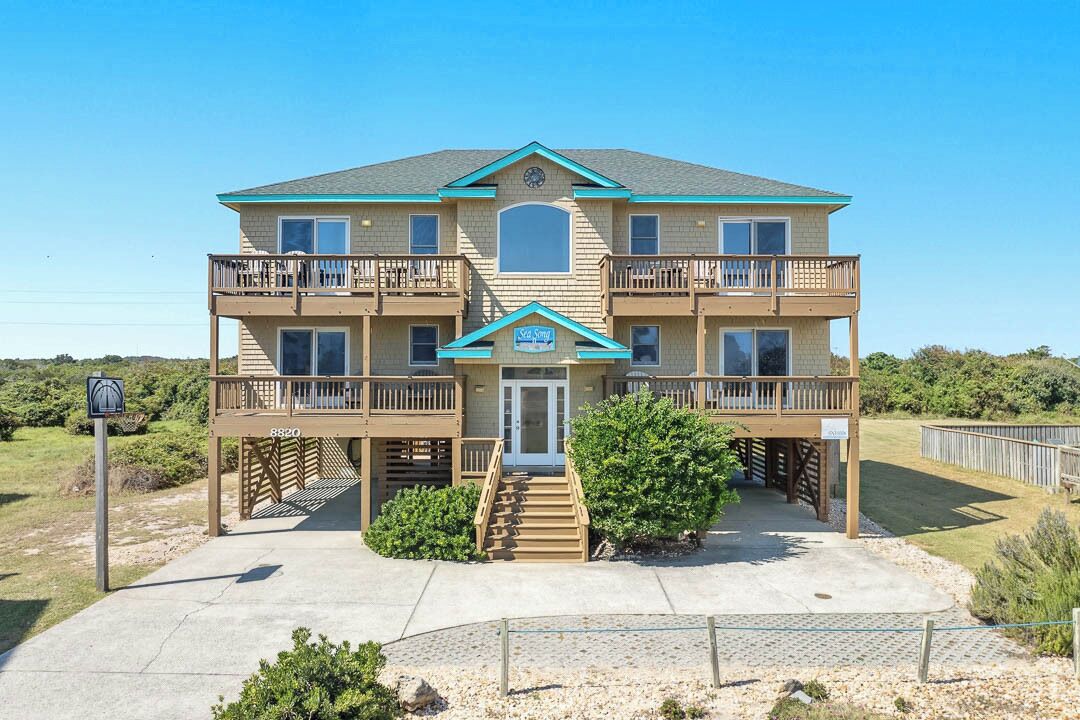 A two-story building with a balcony on each floor, a central entrance, and a small porch area.