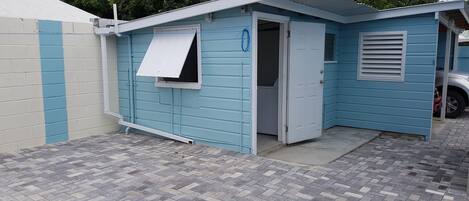 A small, single-story building with a blue exterior and a white door.