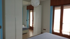 A bedroom with a bed, wardrobe, and a mirror. - Apartment in Malcesine on Lake Garda. New, with panoramic Parking. (Malcesine)