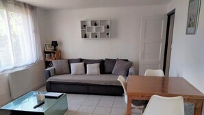 A living room with a sofa, a glass coffee table, a wooden dining table with chairs, and a bookshelf. - House / Villa - Agon Coutainville (Agon-Coutainville)