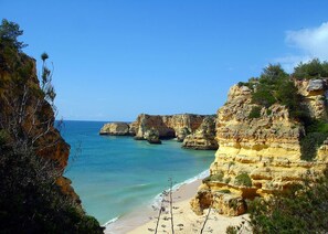 A coastal landscape with cliffs and a beach.