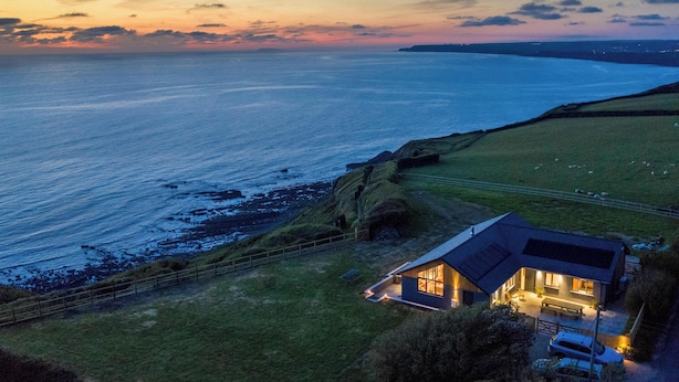 A coastal house with a view of the sea, a fenced yard, and a small dock. - Stunning luxury cliff top retreat - direct access to the South West Coast Path. (Bude)