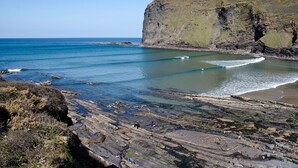 A coastal landscape with rocky terrain and a cliff overlooking the sea. - Stunning luxury cliff top retreat - direct access to the South West Coast Path. (Bude)
