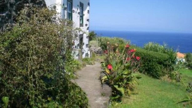 A coastal building with a pathway leading to the sea. - Country Cottage - Cedros, typical Azorien Big House with garden and seaview (Cedros)