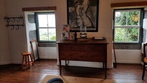 A room with a wooden desk, a framed picture, and two windows with views of greenery. - Country Cottage - Cedros, typical Azorien Big House with garden and seaview (Cedros)