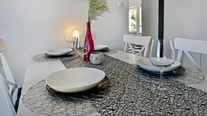A dining table set with plates, glasses, and a decorative vase. - Stylish Casa Lavanda with private pool and garden in Vrsar (Vrsar)