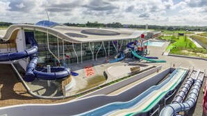 A modern building with multiple water slides and a pool area.