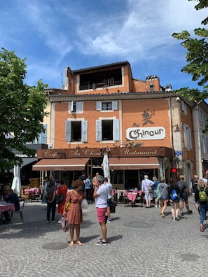 Enjoy meals and drinks in the lively outdoor café area, surrounded by the charming architecture of Au Chien du Rêve Restaurant.