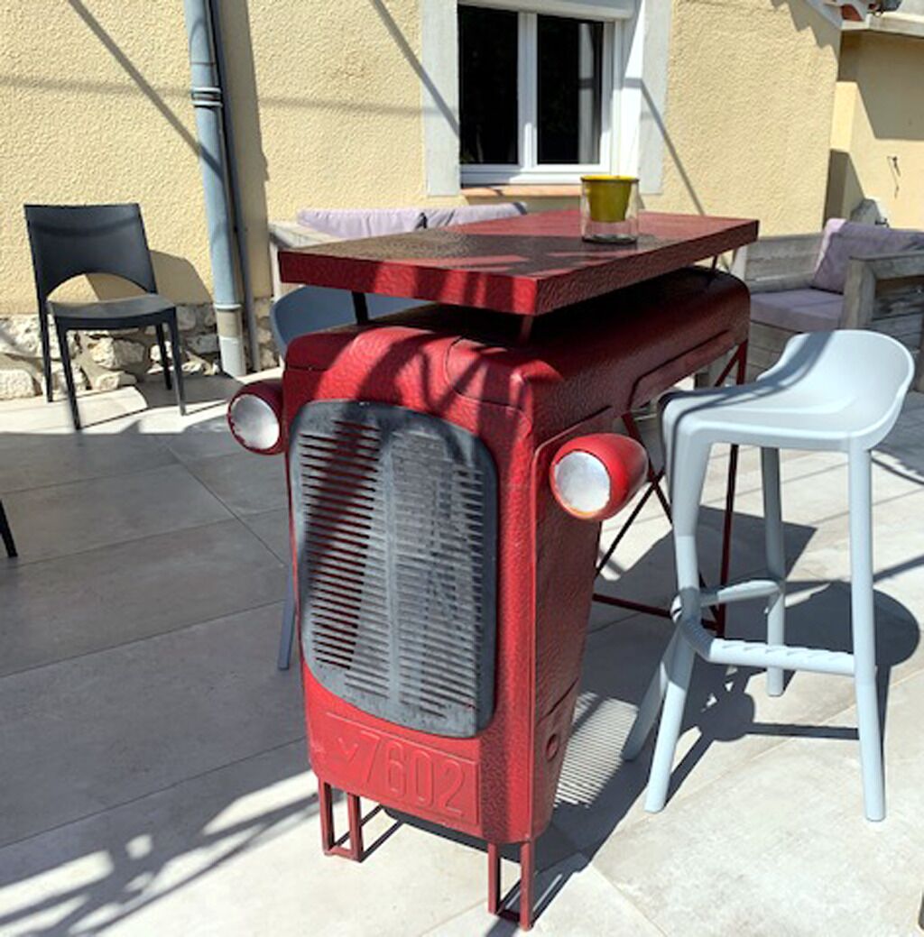 A vintage red radio with the model number 7602, placed on a table with a yellow cup.