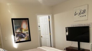A bedroom with a bed, a television, and a door.