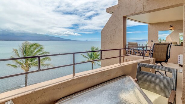 A balcony with a view of the sea, a table, chairs, and a small bar area. - Wake, Sip and Savor the Views in Your 2BR Escape (Wailuku)