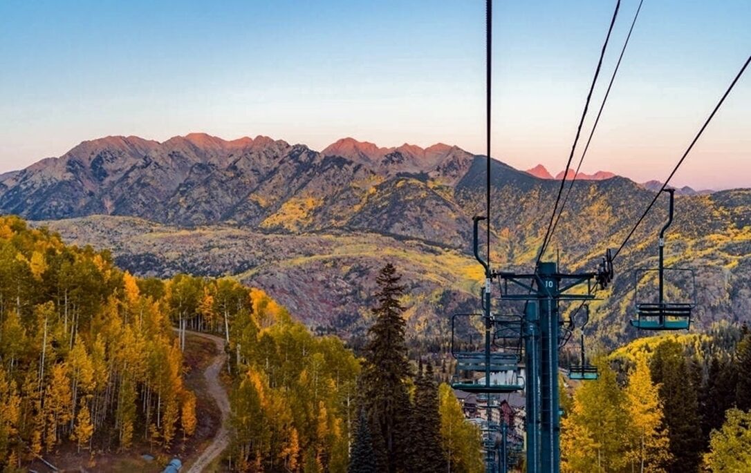 A mountain landscape with a ski lift and a winding road.