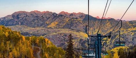 A mountain landscape with a ski lift and a winding road.