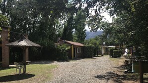A gravel path leading to a building with a thatched roof structure and a small table with a chair. - Sol y Luna (Los Molles)