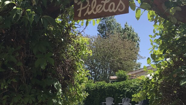 A pool area with a sign reading "Piletas" and a stone pathway leading to it. - Sol y Luna (Los Molles)