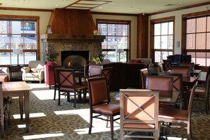 Cozy seating areas surround a warm fireplace, with comfortable chairs and sofas, and large windows offering views of the outside.