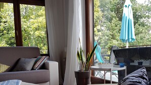 Une pièce confortable avec un canapé, un lit et une table sur laquelle est posée une plante en pot.