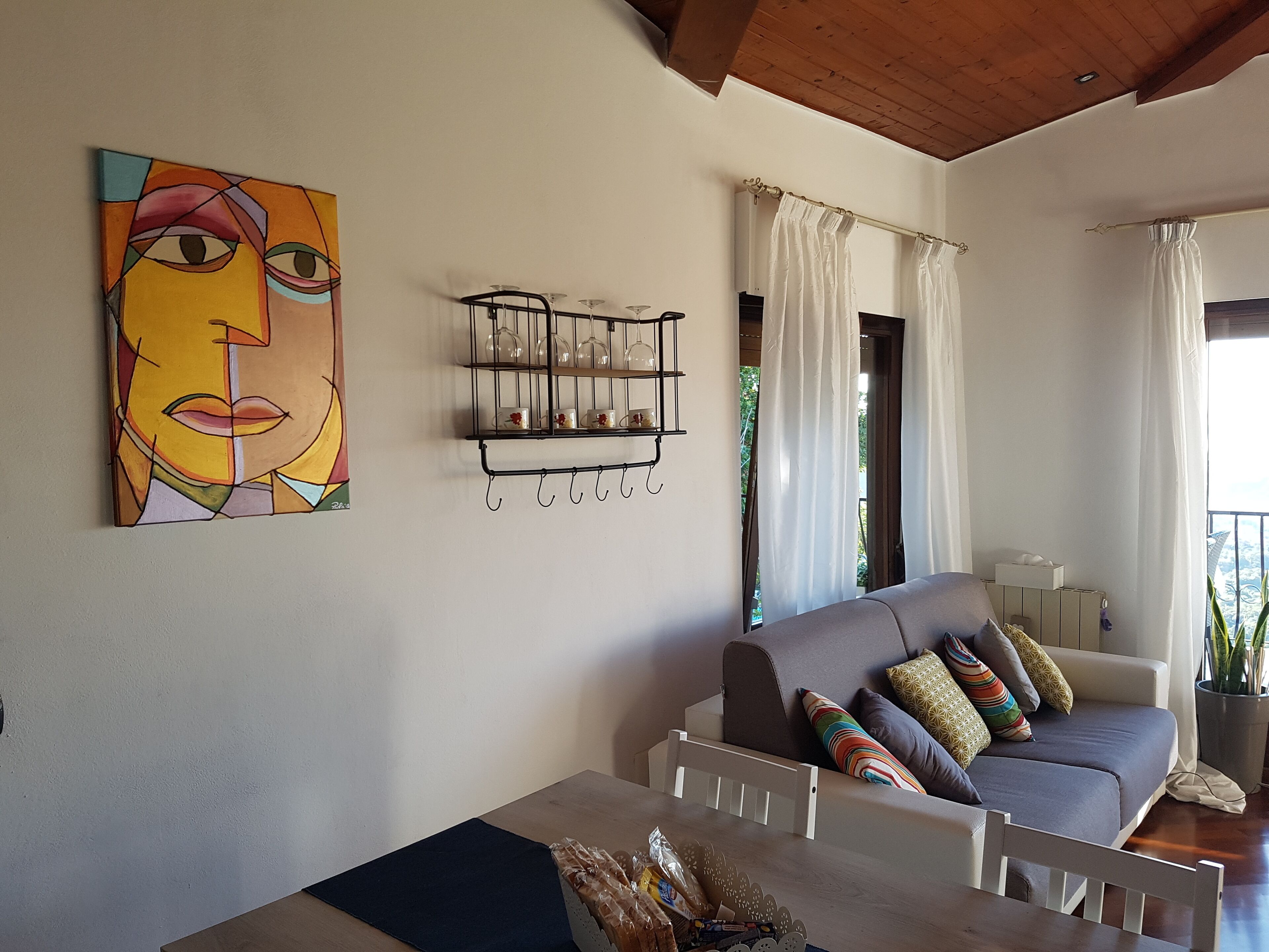 A living room with a grey sofa, a coffee table, and a painting on the wall.