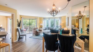 Een ruime hotelkamer met een balkon, een zithoek en een grote spiegel die de kamer weerspiegelt.
