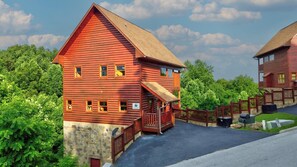 Eine rote Blockhütte mit Steinunterbau, einer Holzterrasse und einer Satellitenschüssel.