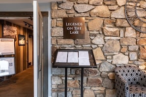 A stone wall with a plaque reading 'Legends on the Lake' and a menu board. - Lake Lure North Carolina | Family Lake Retreat | Pool + Lake | 2BR (Lake Lure)