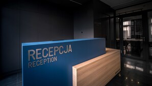 Een receptiebalie met een blauw bord waarop 